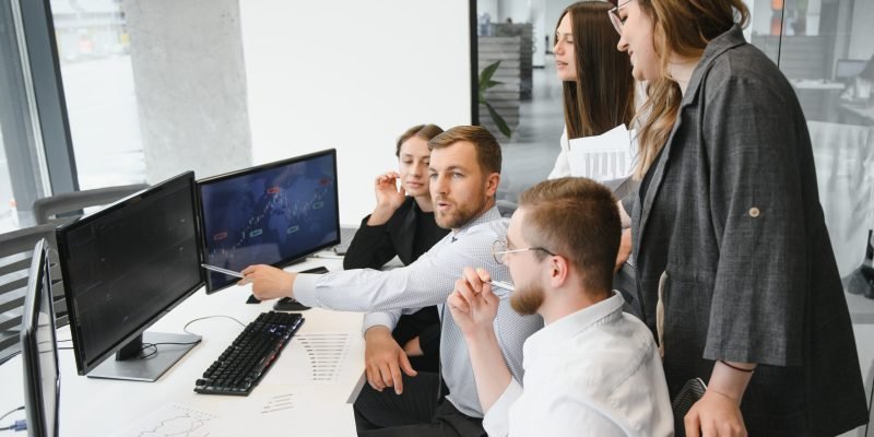 Group of businessmen and businesswomen stock brokers working at office