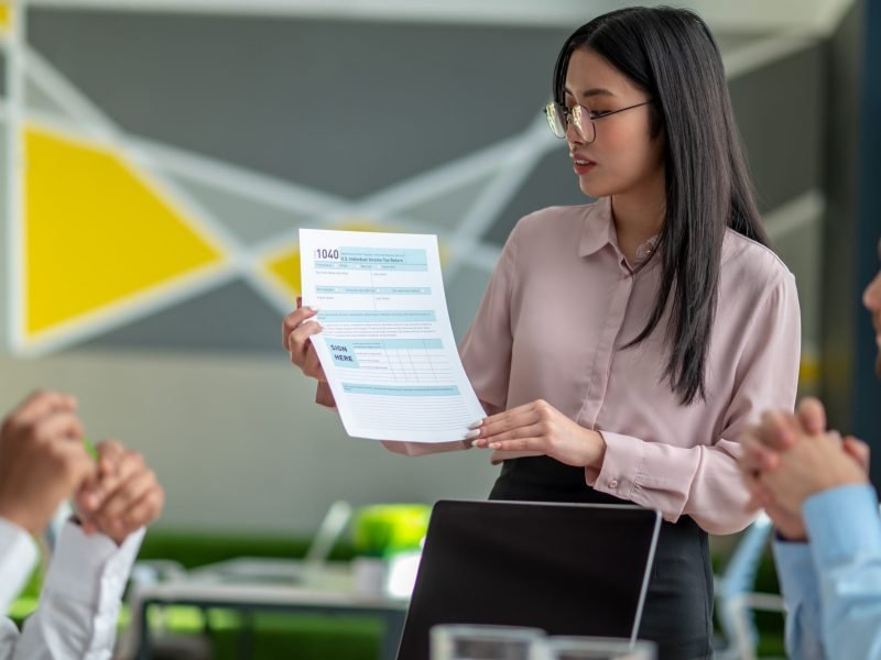 Presentation. Long-haired brunette talking with business partners in the office