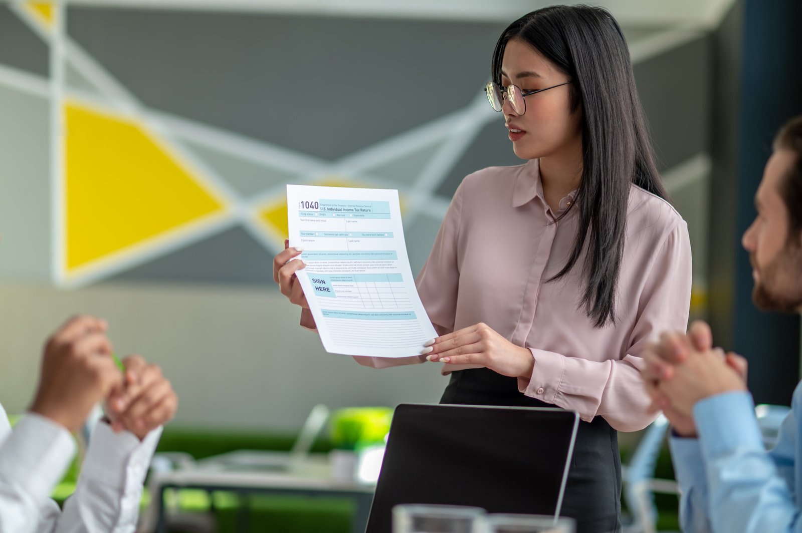 Presentation. Long-haired brunette talking with business partners in the office